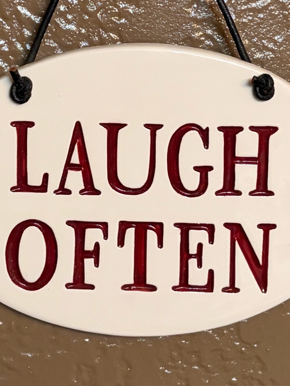 Laugh Often Oval Ceramic Hanging Sign - White with Red Lettering